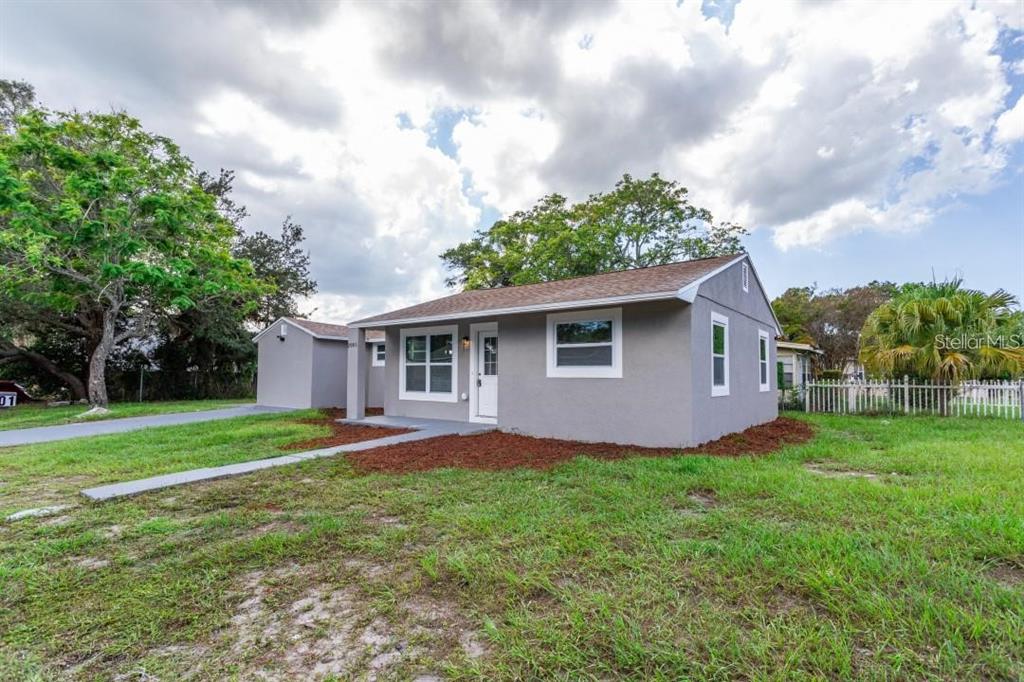 A single-story gray house with a detached garage sits on a grassy lot — 2001 45TH STREET S, ST PETERSBURG, FL