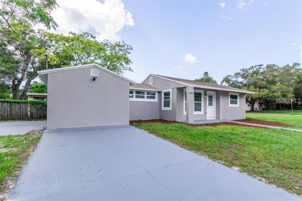 A gray single-story house features a paved driveway, a front entrance, and a grassy yard — 2001 45TH STREET S, ST PETERSBURG, FL