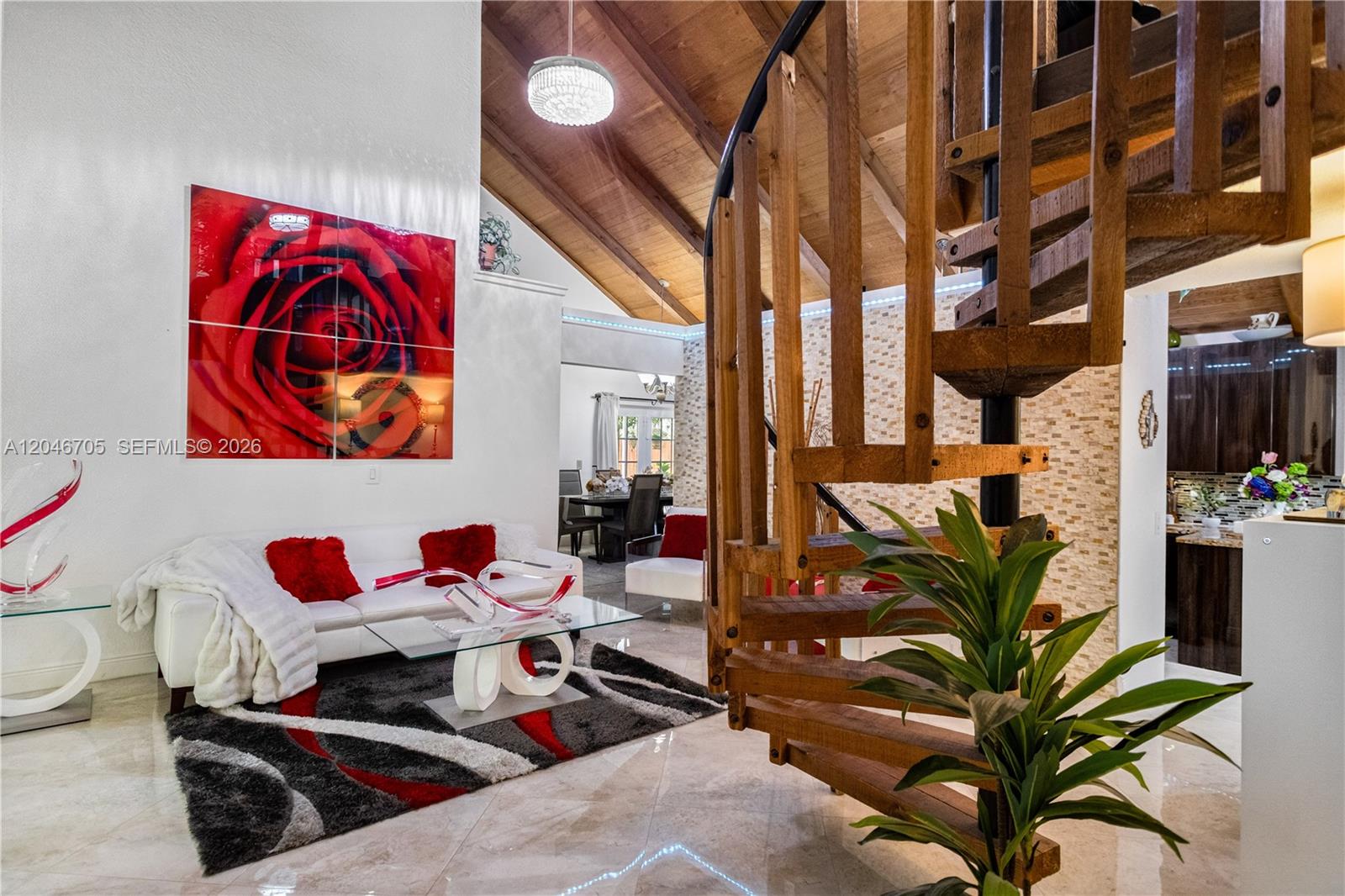A living room features a spiral staircase, vaulted wood ceiling, and red rose wall art — 2620 Buttonwood Ave, Miramar FL 33025, MIRAMAR, FL