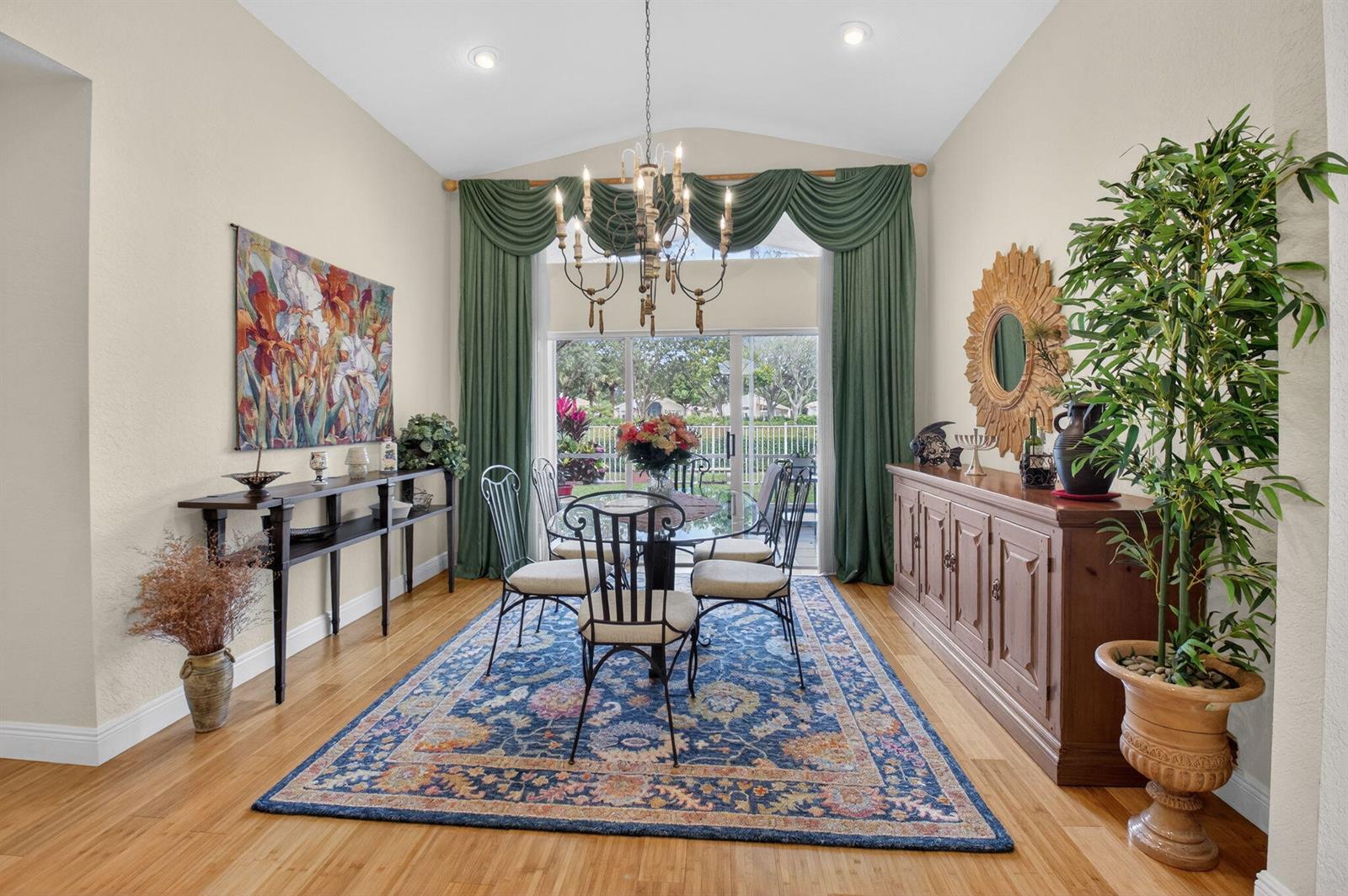 A dining room features a glass table, wrought iron chairs, a blue rug, and green curtains — 6877 Castlemaine Avenue, Boynton Beach FL 33437, BOYNTON BEACH, FL