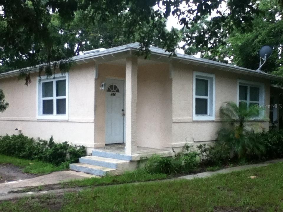 A single-story, light-colored stucco house with a small front porch and steps — 486 OAK STREET, NEW SMYRNA BEACH, FL