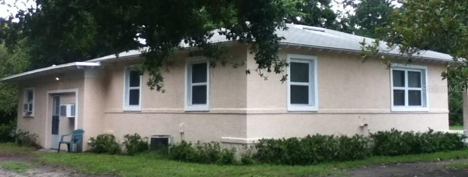 A light-colored, single-story house with a hip roof sits on a grassy lot — 486 OAK STREET, NEW SMYRNA BEACH, FL