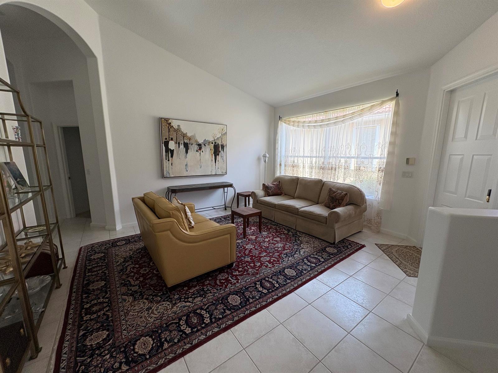 A living room features a large patterned rug, two sofas, a console table, and tile flooring — 15426 Fiorenza Circle, Delray Beach FL 33446, DELRAY BEACH, FL