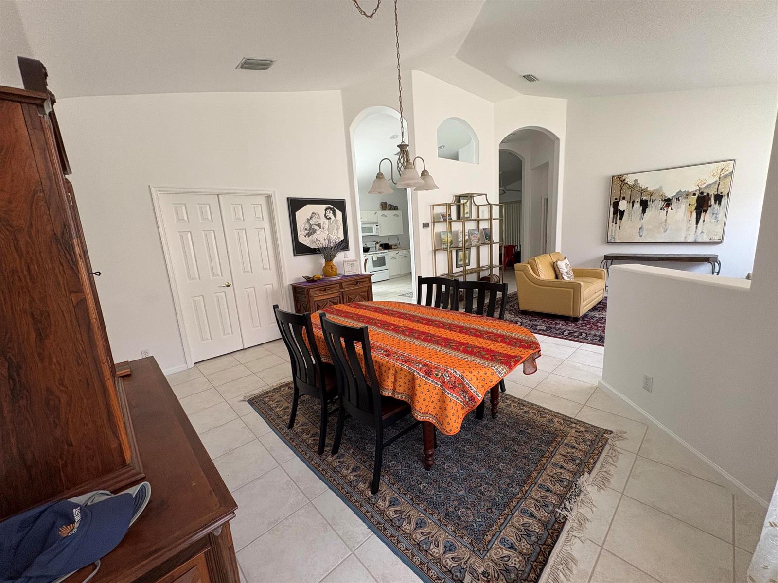 A dining area with a patterned tablecloth, dark chairs, and a rug on tiled floors — 15426 Fiorenza Circle, Delray Beach FL 33446, DELRAY BEACH, FL
