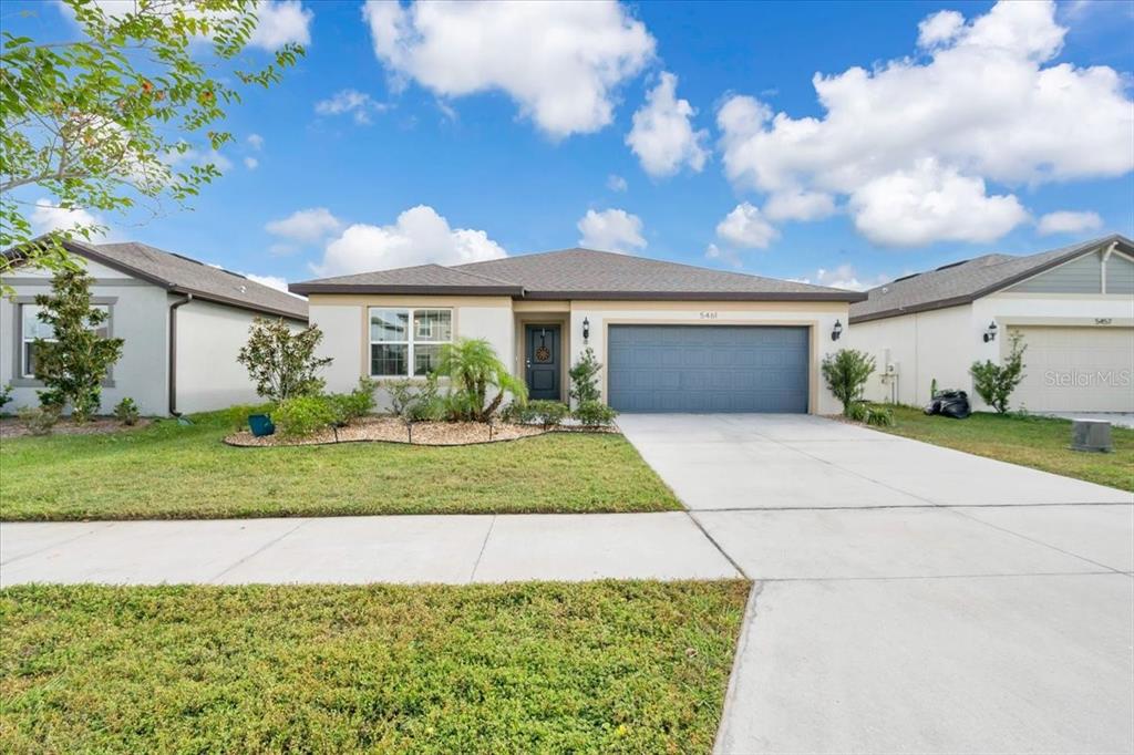 A single-story suburban house features a gray garage, a front entrance, and a landscaped yard — 5461 KEATON SPRINGS DRIVE, LAKELAND, FL