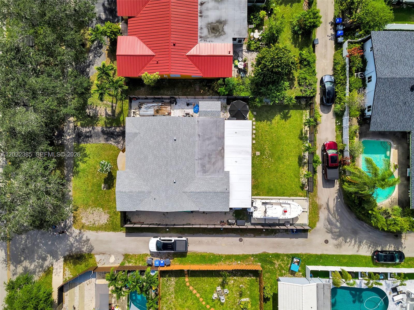 An aerial view shows a house with a gray roof, a boat, and surrounding properties — 4621 Johnson St, Hollywood FL 33021, HOLLYWOOD, FL