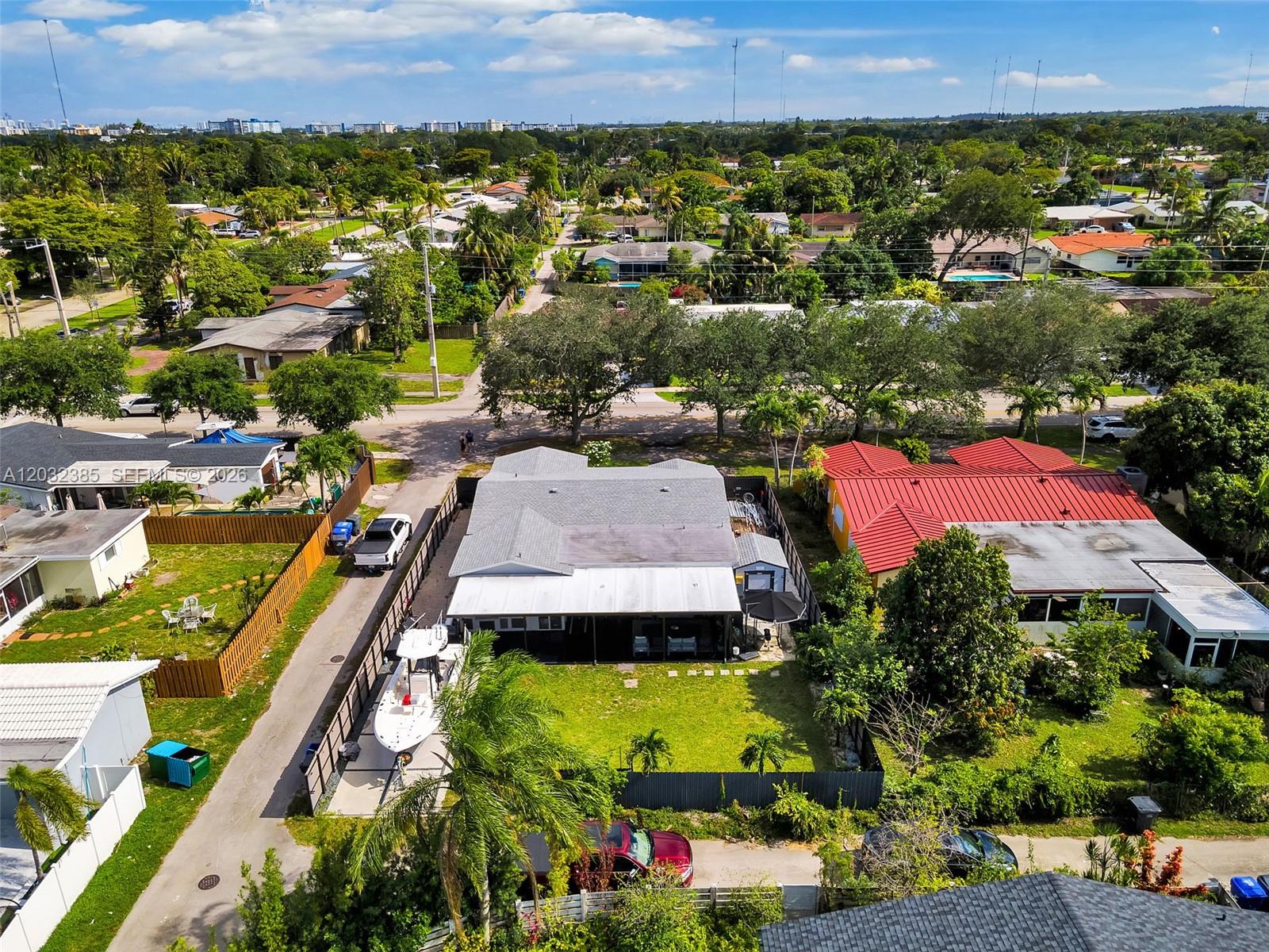 An aerial view shows a residential neighborhood with houses, a boat, and parked vehicles — 4621 Johnson St, Hollywood FL 33021, HOLLYWOOD, FL