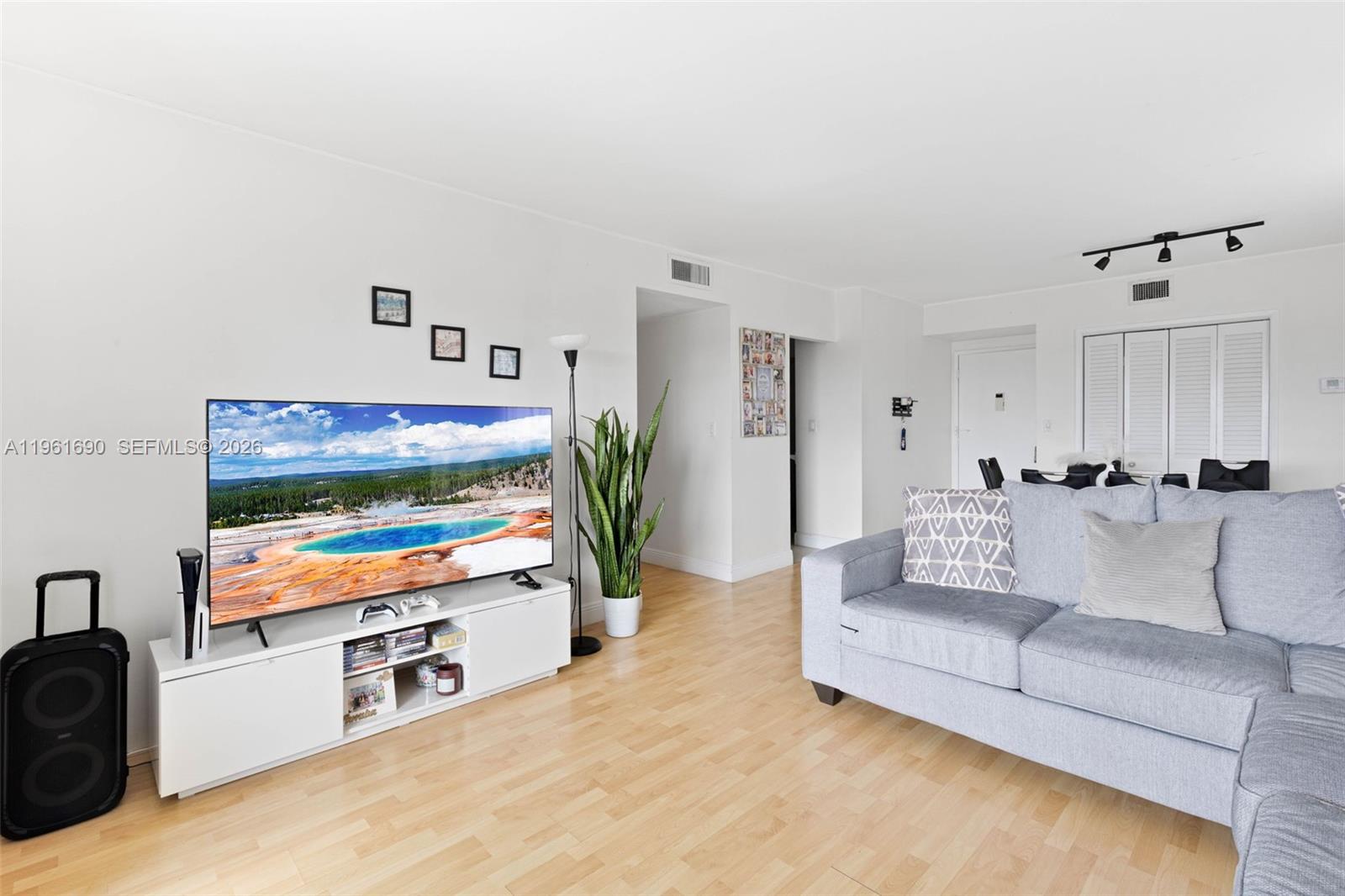 A living room features a large television on a white stand, sofa, and hardwood floors — 4400 Hillcrest Dr # 901B, Hollywood FL 33021, HOLLYWOOD, FL