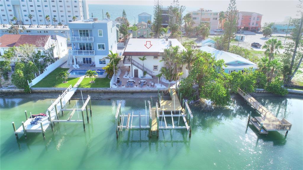 A two-story building with a red tile roof, palm trees, and an outdoor staircase — 8535 BLIND PASS DRIVE UNIT 103, TREASURE ISLAND, FL