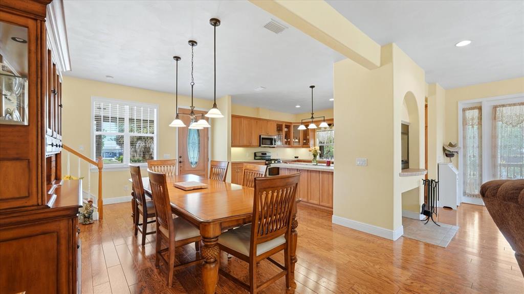 A dining room with a wooden table and chairs sits adjacent to a kitchen area — 280 W COWLES STREET, ENGLEWOOD, FL