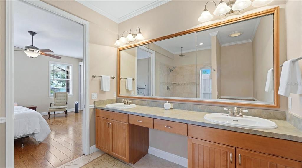 A bathroom features a double vanity with wood cabinets, a large mirror, and an adjacent bedroom — 280 W COWLES STREET, ENGLEWOOD, FL