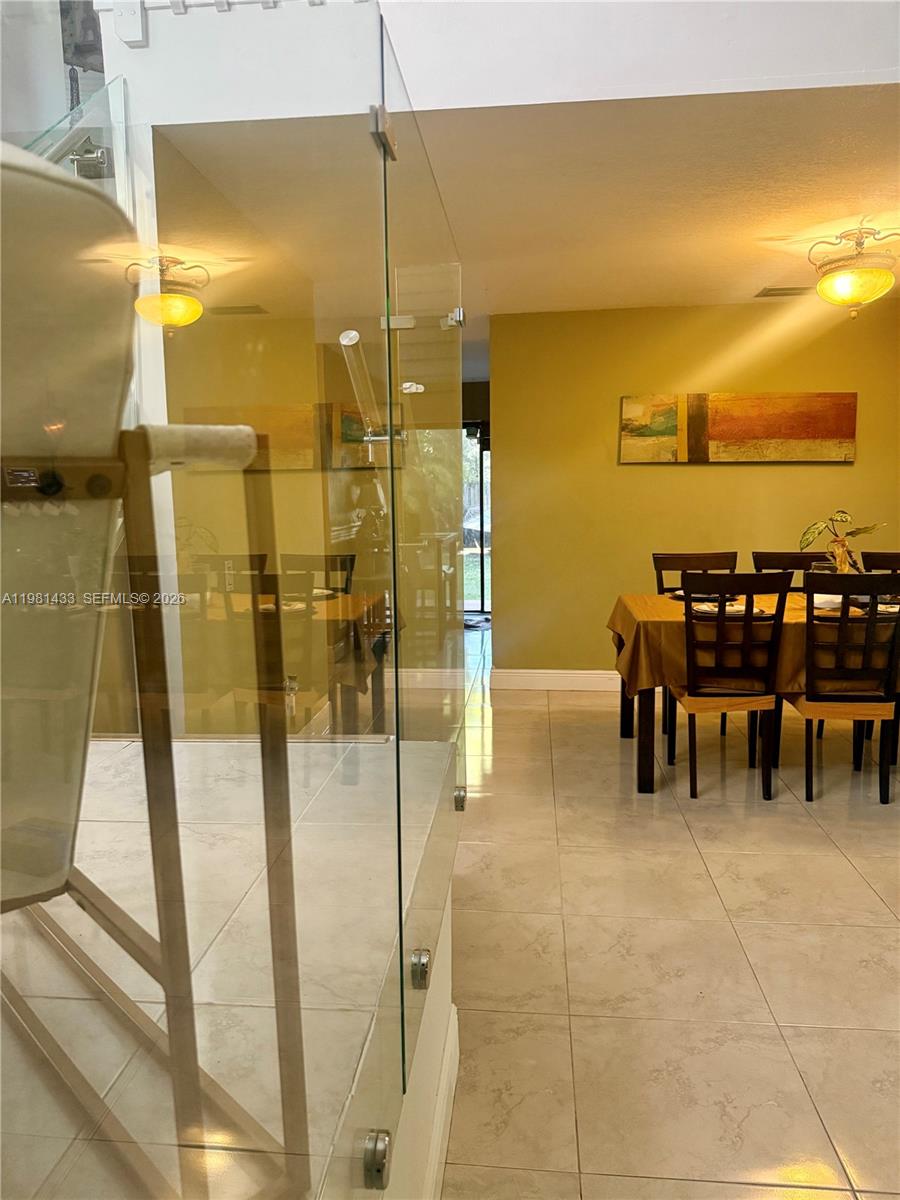 A dining area with a table and chairs is visible through a glass partition — 5119 SW 153rd Pl N, Miami FL 33185, MIAMI, FL