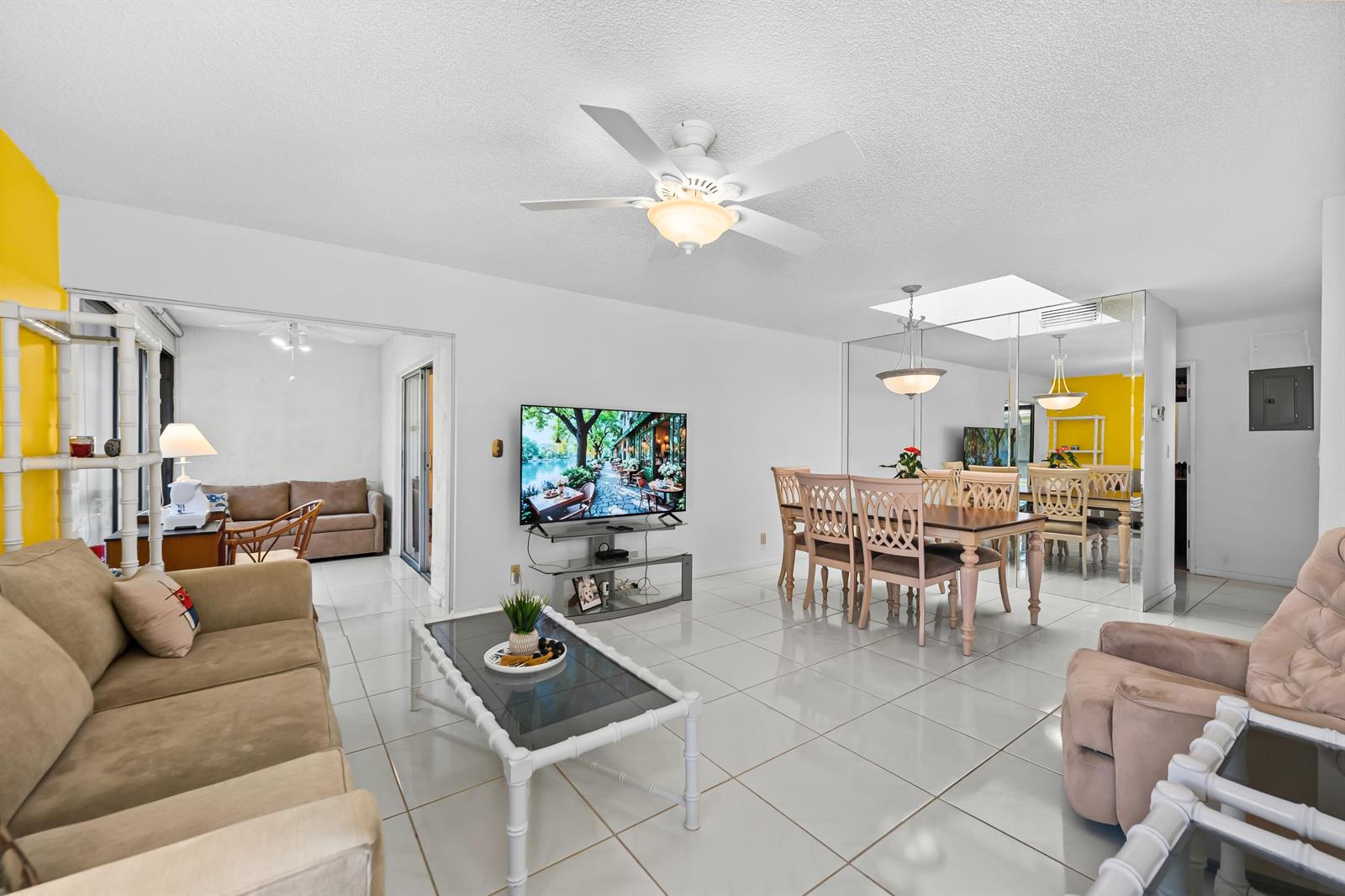 A living and dining area with white tile floors, a ceiling fan, and mirrored walls — 18762 Candlewick Drive, Boca Raton FL 33496, BOCA RATON, FL