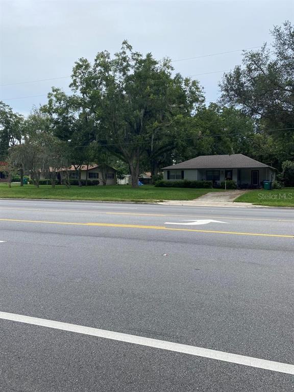 A street view of two single-story houses with large trees and a paved road — 24809 W NEWBERRY ROAD, NEWBERRY, FL