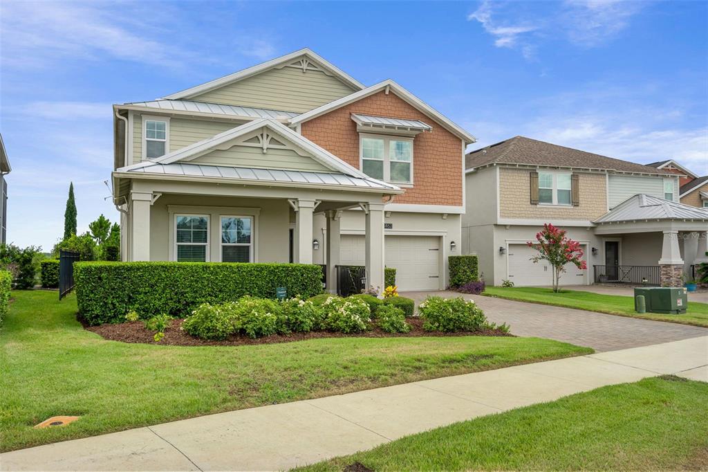 A two-story suburban house with a green exterior, a front porch, and a paved driveway — 3462 SHALLOW COVE LANE, CLERMONT, FL