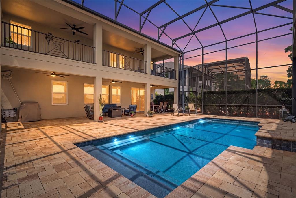 A two-story house with a screened-in pool and patio area at sunset — 3462 SHALLOW COVE LANE, CLERMONT, FL