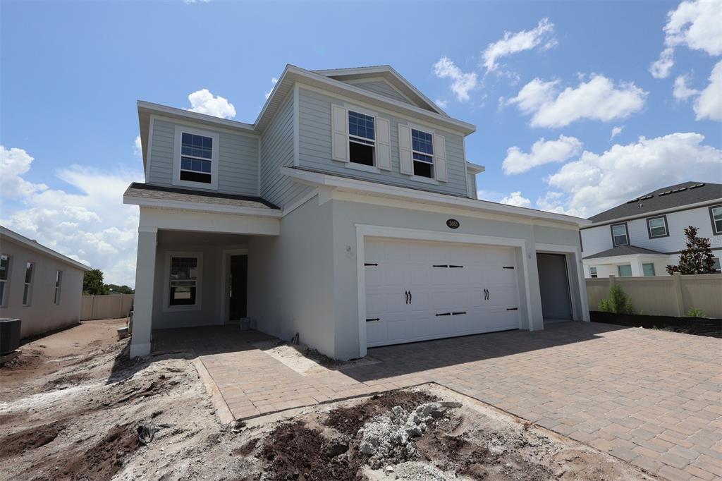 A kitchen with dark cabinets, a white island, and light flooring opens into a living area — 2685 GREAT HERON AVENUE, ST CLOUD, FL