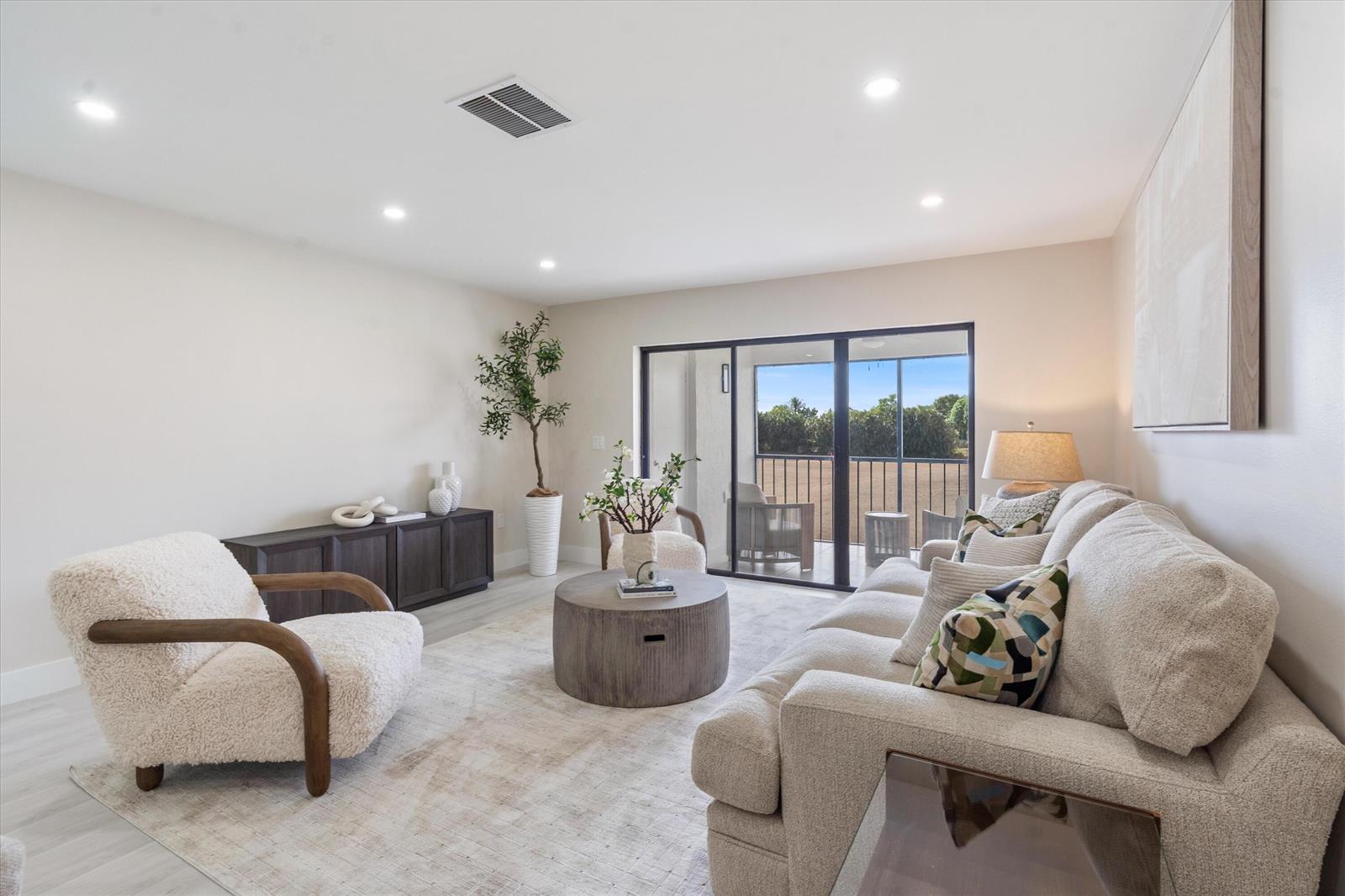A living room features a sofa, an armchair, a coffee table, and a sliding glass door — 47 Stratford Lane W # F, Boynton Beach FL 33436, BOYNTON BEACH, FL