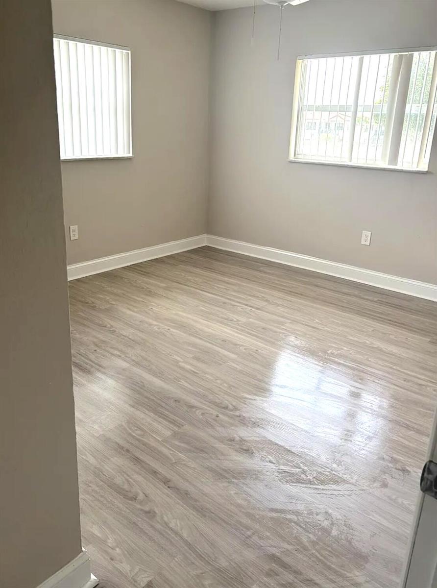 An empty room with light gray walls, white trim, and light wood-look laminate flooring — 601 SW 2nd Avenue # 5, Boca Raton FL 33432, BOCA RATON, FL