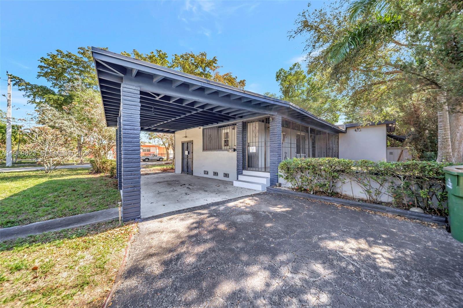 A single-story house features a dark-painted brick carport and a gated front entryway — 890 NE 138th St, North Miami FL 33161, NORTH MIAMI, FL