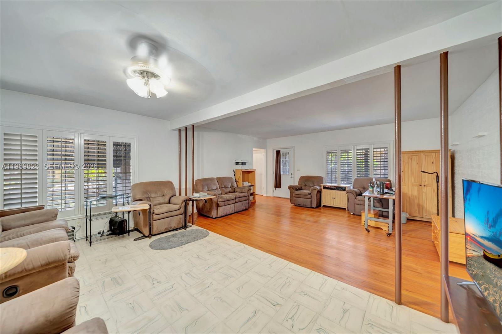 A living room features a mix of tile and wood flooring with brown recliner furniture — 890 NE 138th St, North Miami FL 33161, NORTH MIAMI, FL