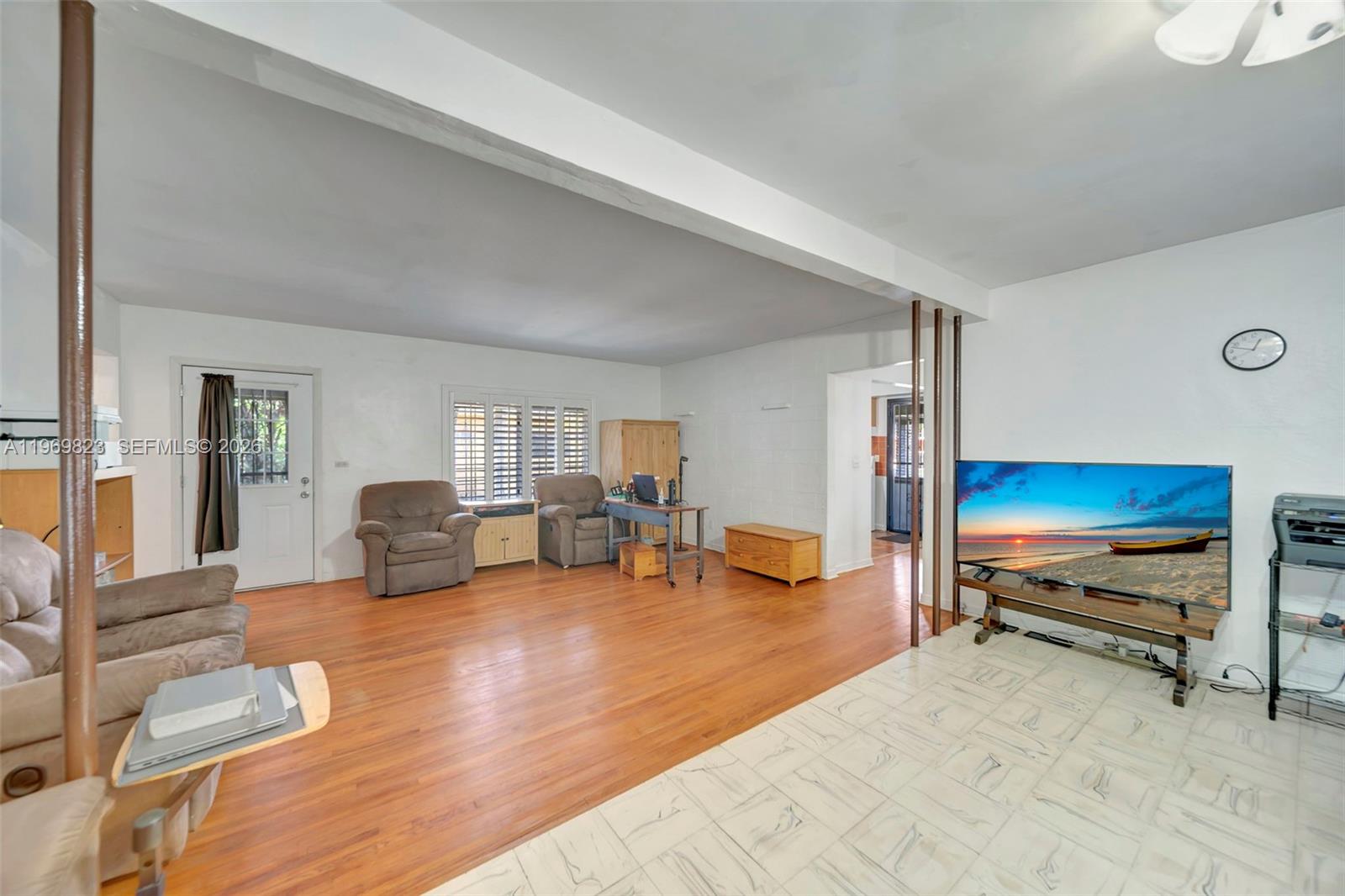A living room features wood flooring, a tiled area, a television, and a ceiling fan — 890 NE 138th St, North Miami FL 33161, NORTH MIAMI, FL