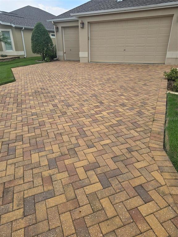 A paved driveway leads to a two-car garage at the front of a suburban house — 3452 BOSIE RUN, THE VILLAGES, FL