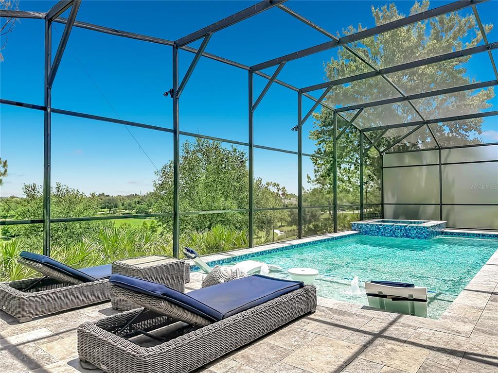 A screened-in patio features a swimming pool with a sun shelf and attached hot tub — 14591 BLACK QUILL DRIVE, WINTER GARDEN, FL