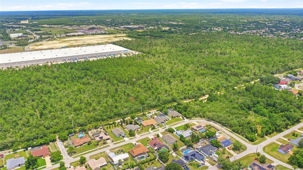 An aerial view shows a wooded lot marked with a white outline near residential homes — EDGEMONT (PAPER) AVENUE, DELTONA, FL
