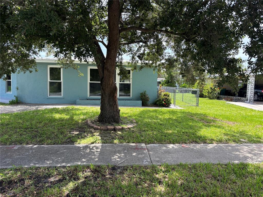 A teal single-story house with a large tree in the front yard — 2513 AMBROSE LANE, PORT CHARLOTTE, FL