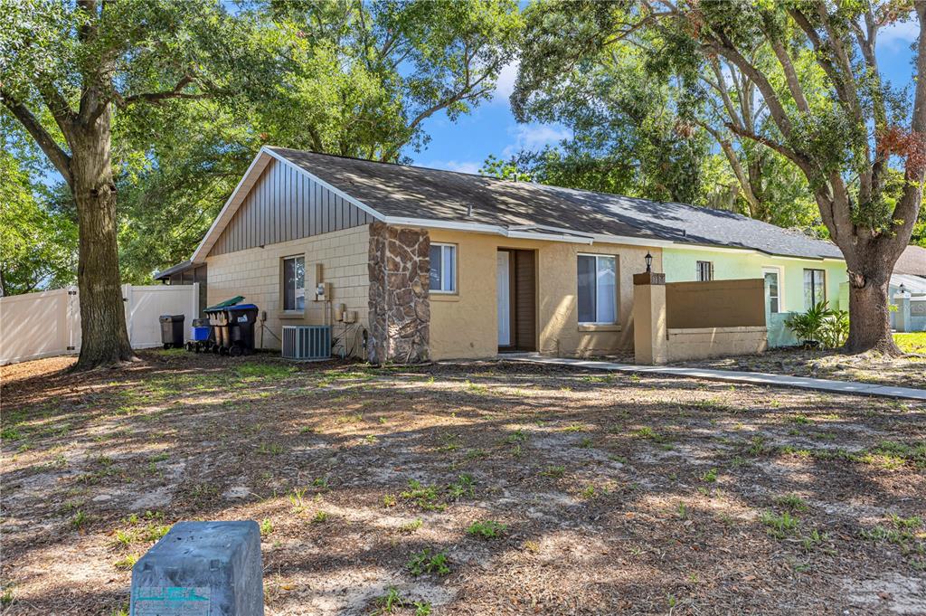 A single-story house with a stone accent wall, tan siding, and a large front yard — 3675 WESTLAND COURT UNIT 1, ORLANDO, FL