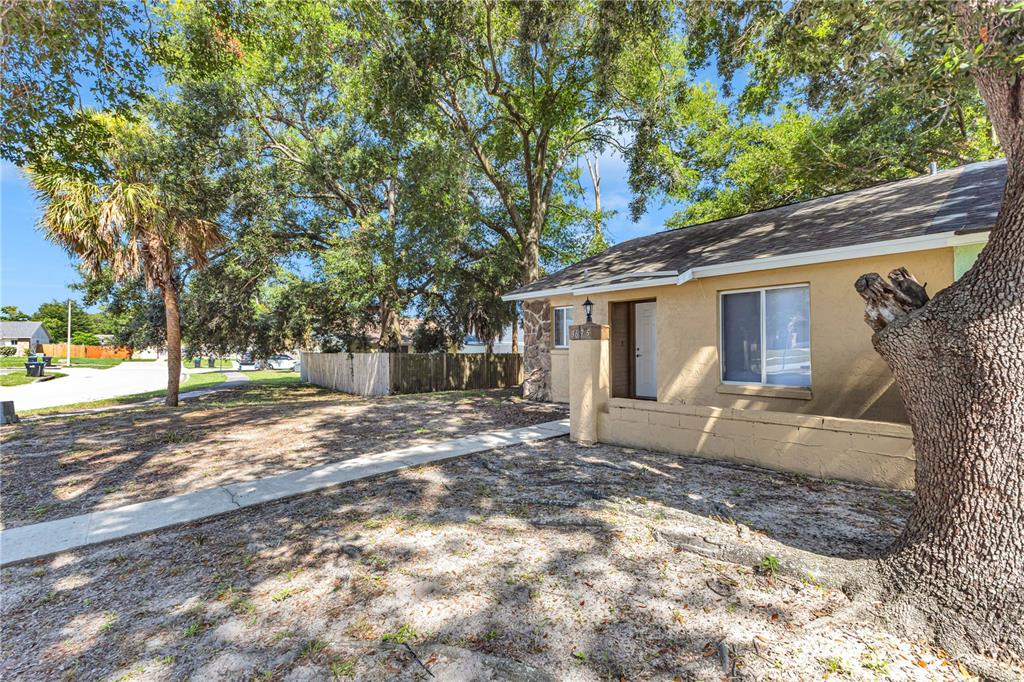 A tan house with a concrete walkway and large trees in the front yard — 3675 WESTLAND COURT UNIT 1, ORLANDO, FL