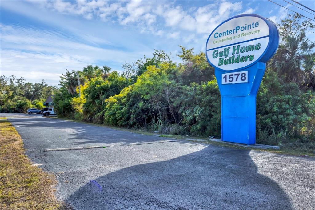 A blue sign for CenterPointe Counseling and Recovery stands beside a paved road and trees — 1578 EL JOBEAN ROAD, PORT CHARLOTTE, FL