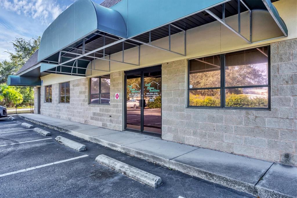 The exterior of a single-story commercial building features a concrete block facade and metal awnings — 1578 EL JOBEAN ROAD, PORT CHARLOTTE, FL