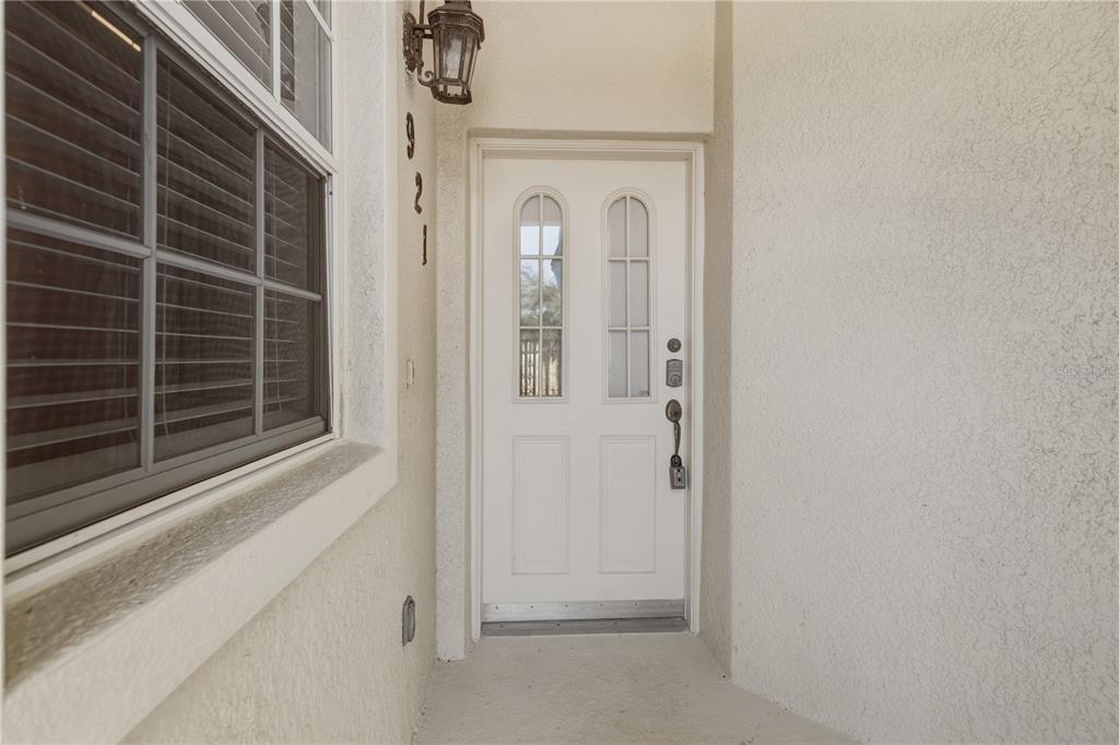 A white front door with two arched windows sits next to a window with blinds — 900 SAN LINO CIRCLE UNIT 921, VENICE, FL