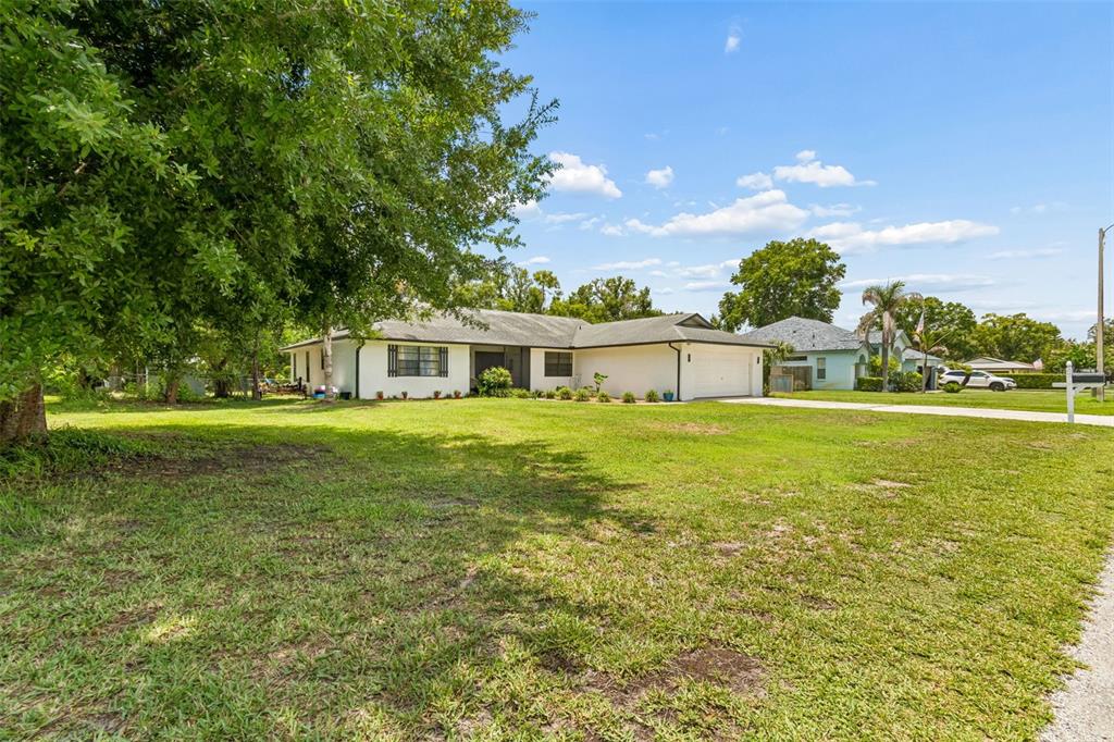 An aerial view shows a residential neighborhood with a house, a canal, and a lake — 22408 SHORESIDE DRIVE, LAND O LAKES, FL