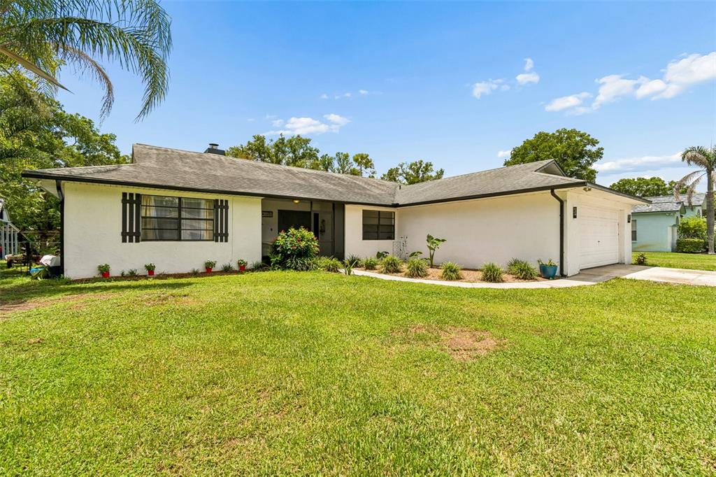 An aerial view shows a house with a backyard leading to a small pond — 22408 SHORESIDE DRIVE, LAND O LAKES, FL