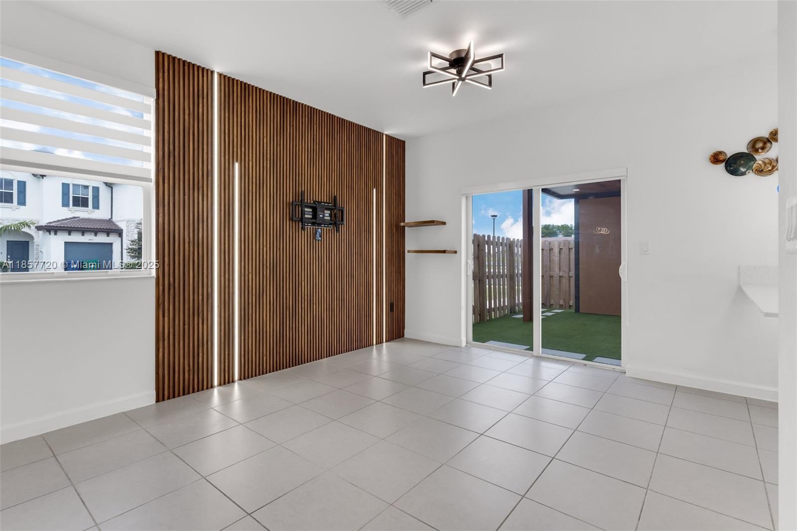 A living room features a wood-slat accent wall with integrated lighting and tile flooring — 12373 NW 24th Pl, Miami FL 33167, MIAMI, FL