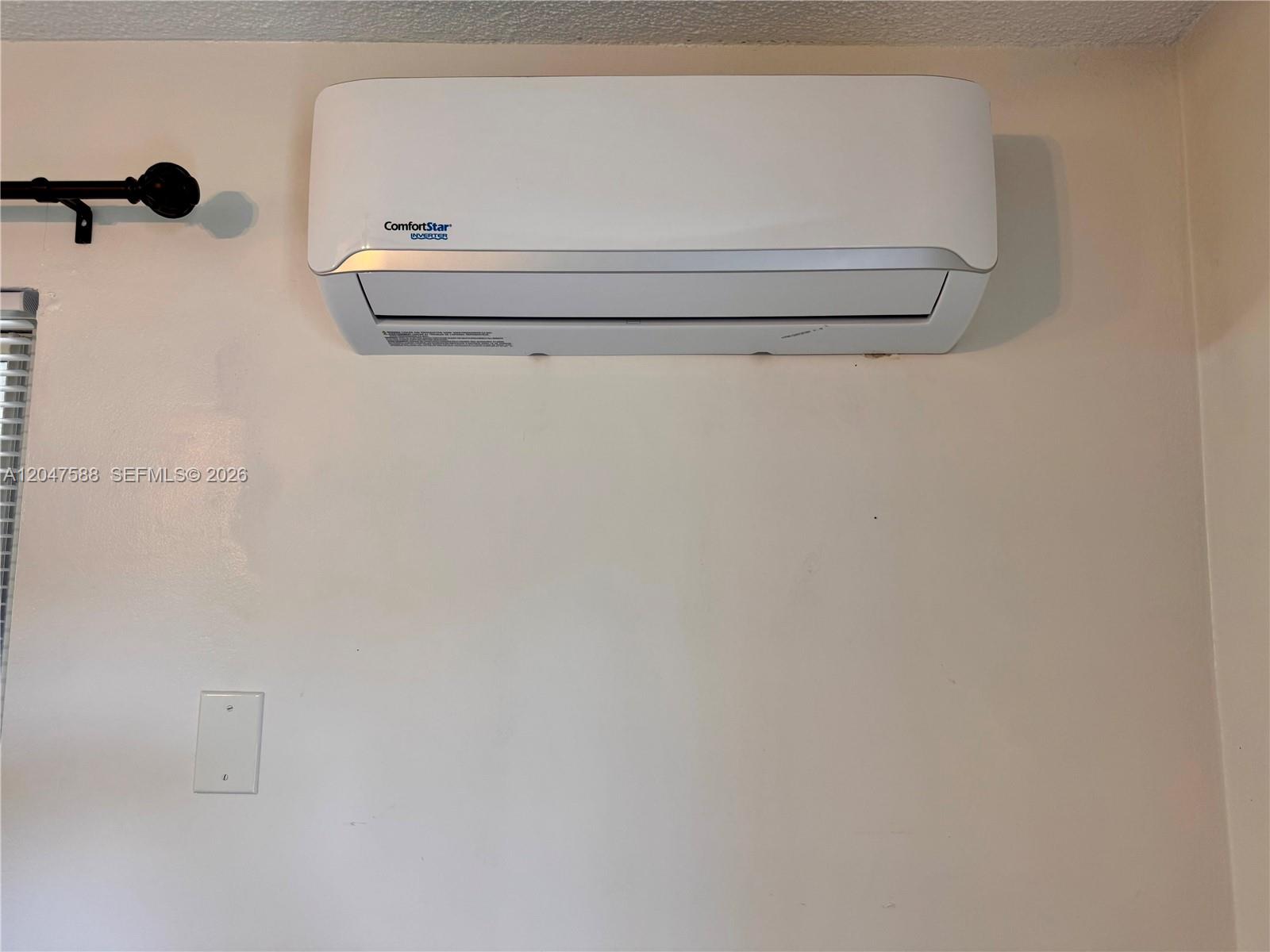 A white wall-mounted ComfortStar mini-split air conditioning unit is installed above a light switch — 1158 NW 34th Ave # 2, Miami FL 33125, MIAMI, FL