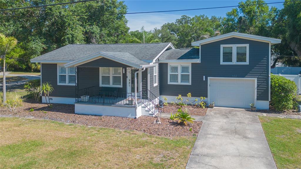 A single-story house with dark gray siding, a front porch, and an attached garage — 602 W HILDA STREET, TAMPA, FL