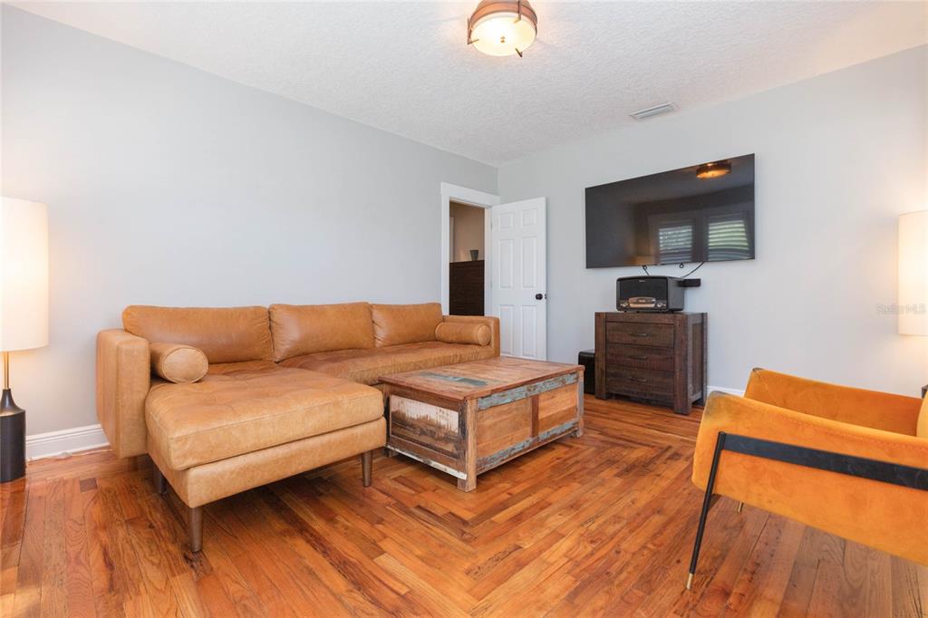 A living room features a tan leather sectional, a wooden coffee table, and hardwood floors — 602 W HILDA STREET, TAMPA, FL