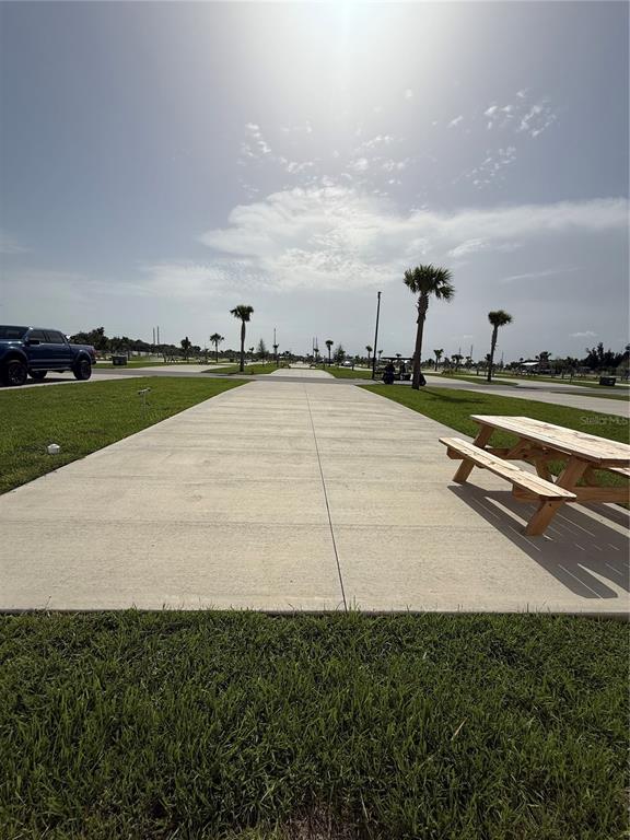 A concrete RV pad features a wooden picnic table on a grassy lot — 201 DELTA DRIVE, PUNTA GORDA, FL