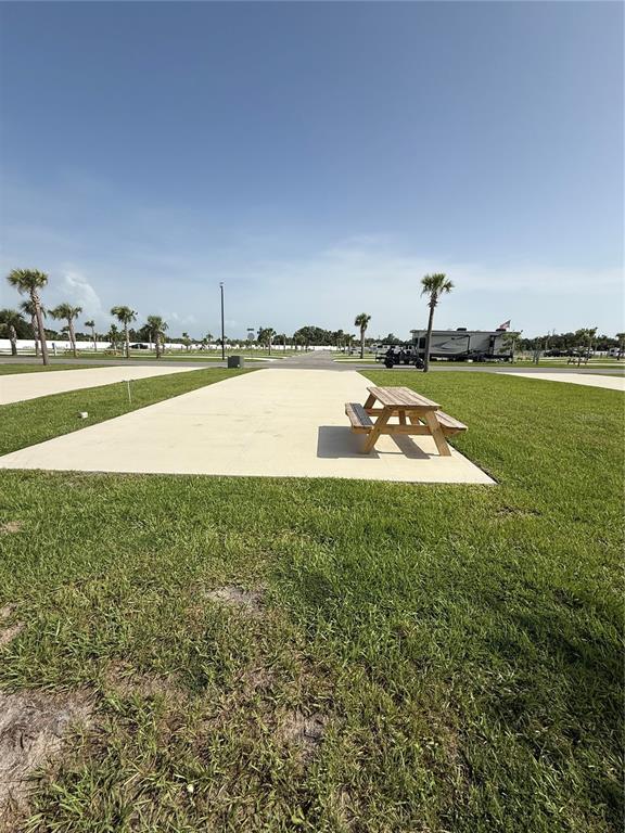 A concrete RV pad features a wooden picnic table on a grassy lot — 201 DELTA DRIVE, PUNTA GORDA, FL
