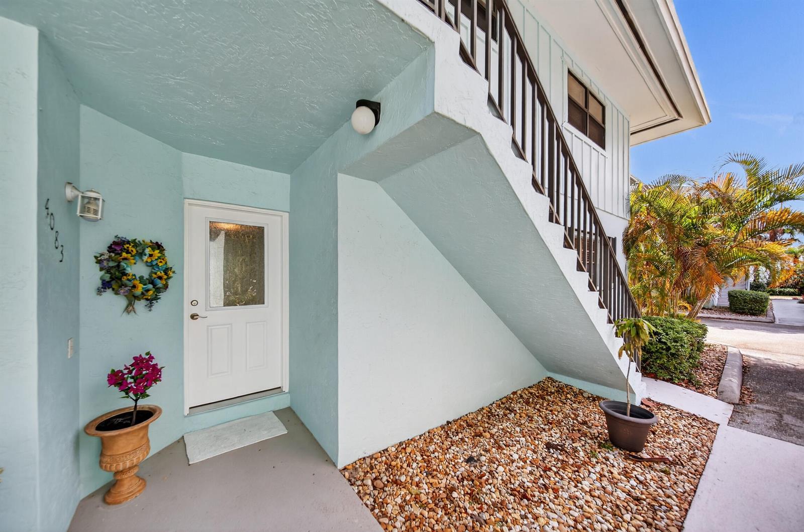 A light blue exterior entrance features a white door, a wreath, and an outdoor staircase — 4083 SE Centerboard Lane # a, Stuart FL 34997, STUART, FL