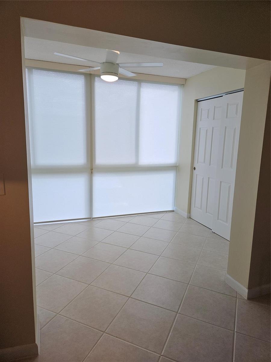 A sunroom with tile flooring, a ceiling fan, large windows with shades, and a closet — 300 NE 26th Avenue, Boynton Beach FL 33435, BOYNTON BEACH, FL