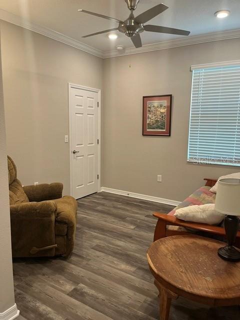 A room with wood-look flooring, a ceiling fan, a brown recliner, and a small sofa — 7285 SW 86TH COURT, OCALA, FL