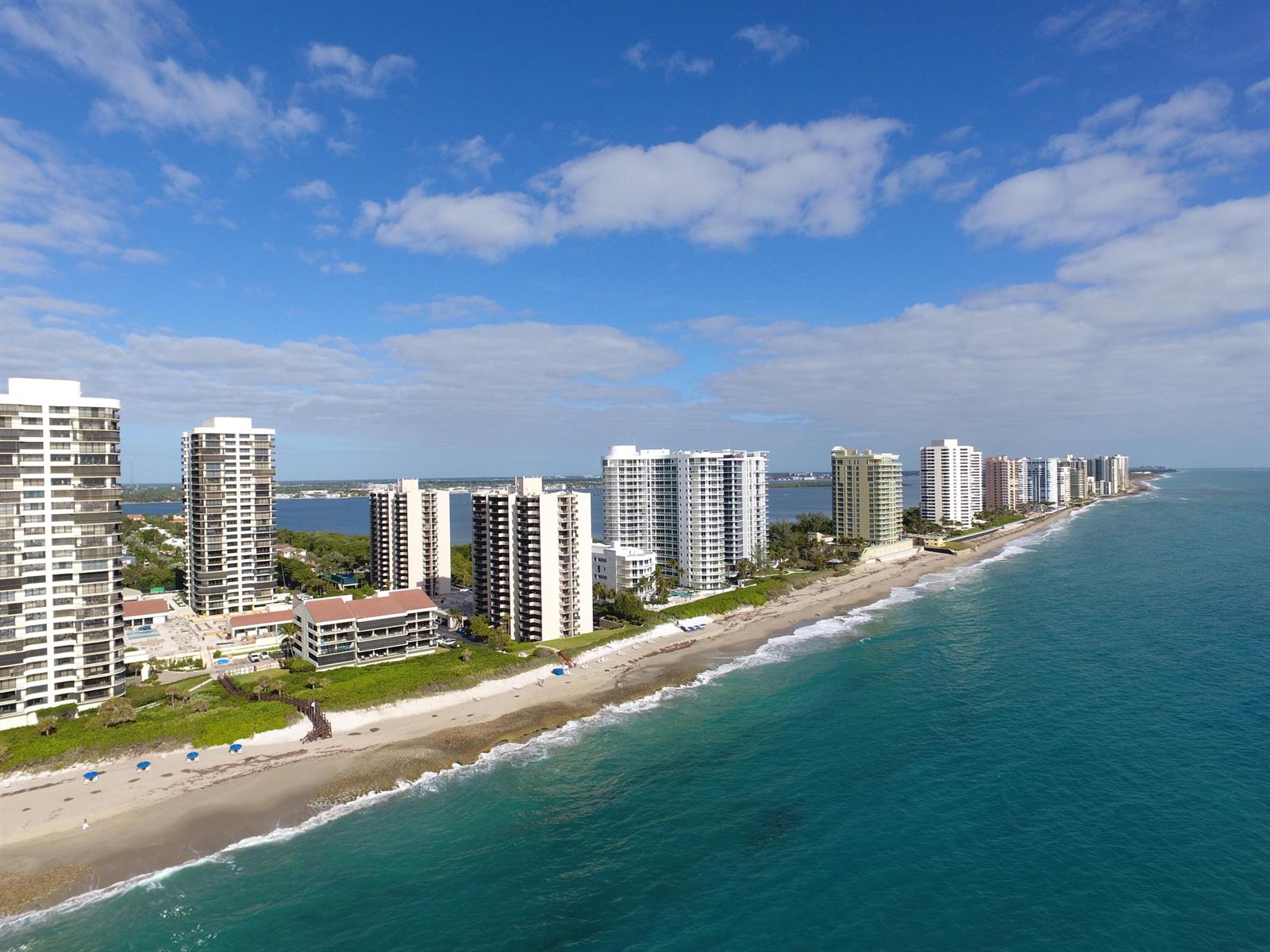 An aerial view of a sandy beach lined with high-rise residential buildings along the ocean — 4200 N Ocean # 203, Singer Island FL 33404, SINGER ISLAND, FL