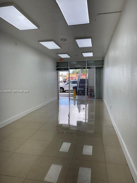 An empty commercial space features white walls, a tiled floor, and recessed ceiling lights — 5755 W Flagler St # 114, Miami FL 33144, MIAMI, FL