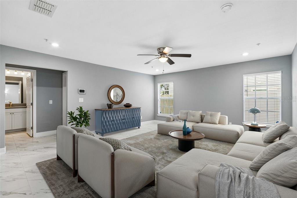 A living room features light gray walls, white tile flooring, a sectional sofa, and a sideboard — 2613 ESPANA COURT, TAMPA, FL