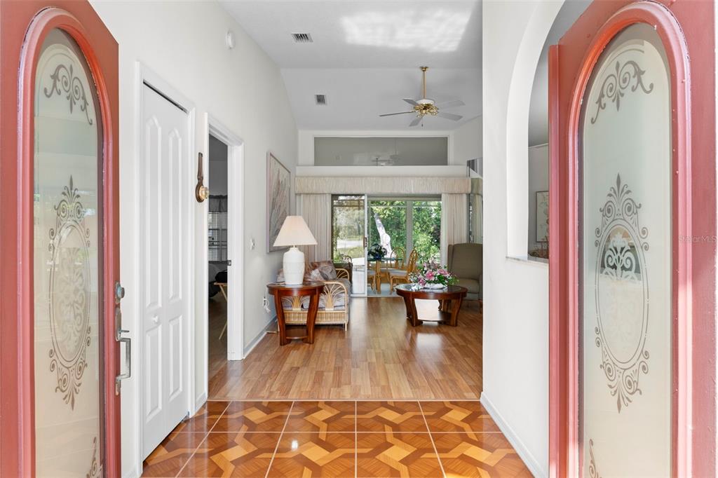 An entryway with patterned tile flooring leads into a living room with wood-look floors — 3047 RIPPLING BROOK WAY, SPRING HILL, FL